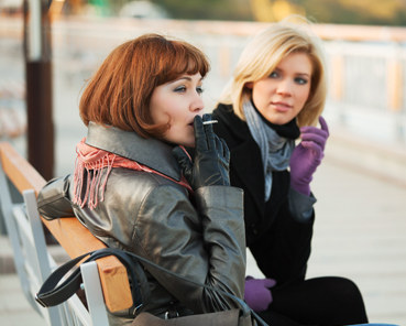 A quitter sitting on a park bench thinking about smoking